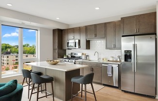 a kitchen with a large island and stainless steel appliances
