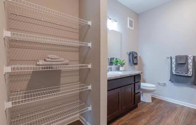 Bathroom with a sink and a toilet and shelves at grove city apartments
