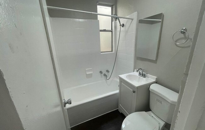 a bathroom with a toilet and a tub and a sink