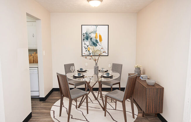 a dining room with a table and chairs and a painting on the wall