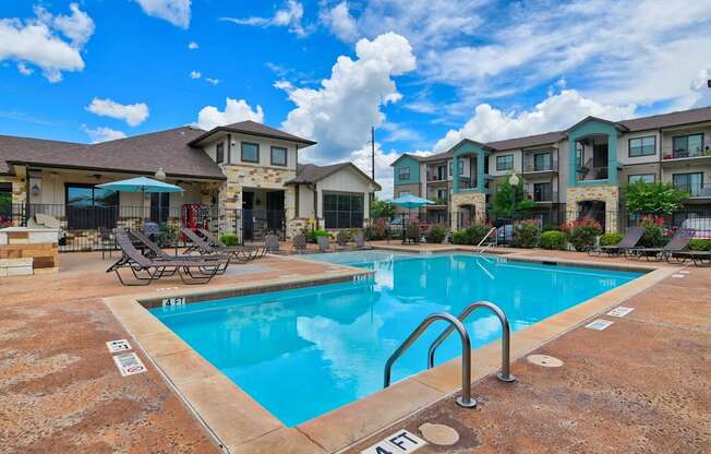 A swimming pool in front of apartment buildings.