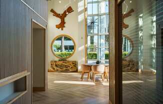 a dining room with a round mirror and a table and chairs