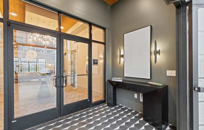 Entrance to a building with glass doors and a black table at Hadley Place Apartments, Pennsylvania