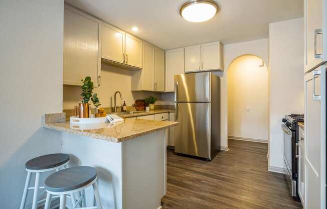 a kitchen with stainless steel appliances and a counter top with three stools
