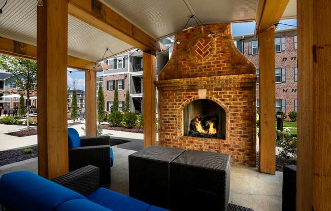 a patio with a brick fireplace and furniture