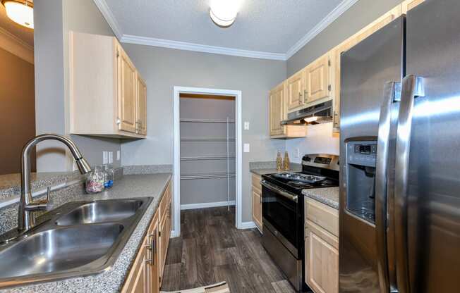 Kitchen with stainless steel appliances and wood cabinets at Elme Eagles Landing in Stockbridge, GA