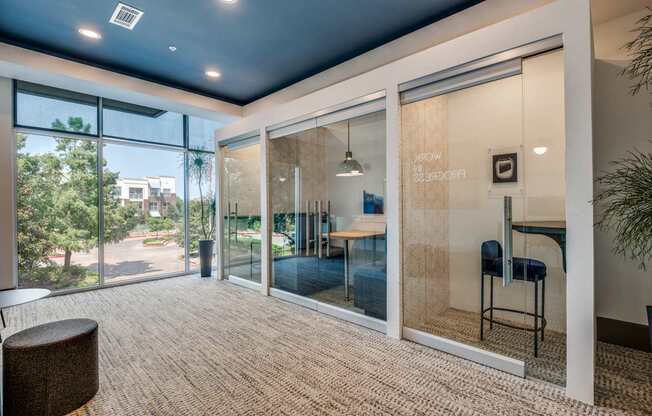 a living room with large glass windows and a rug
