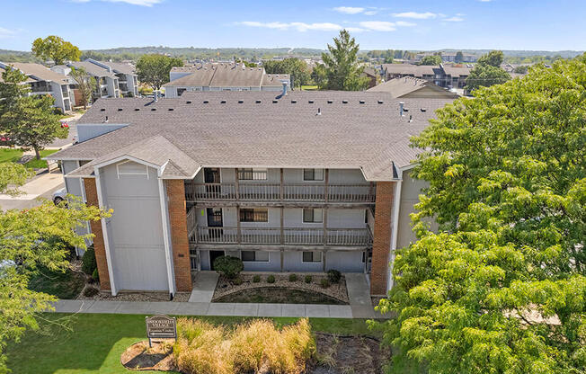 an aerial view of a building with a yard and trees