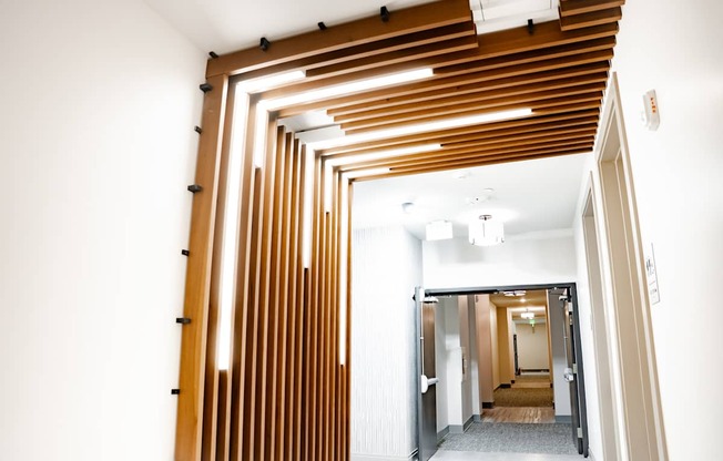 A long hallway with a series of wooden slats on the ceiling.