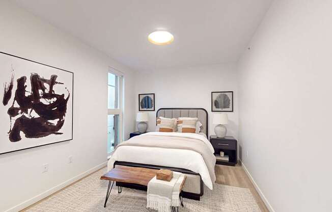 A bedroom with a large bed and a painting on the wall. at One West Drive Apartments, Excelsior, MN 55331