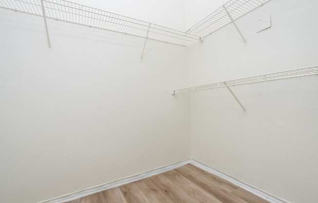 an empty room with white walls and wooden floors