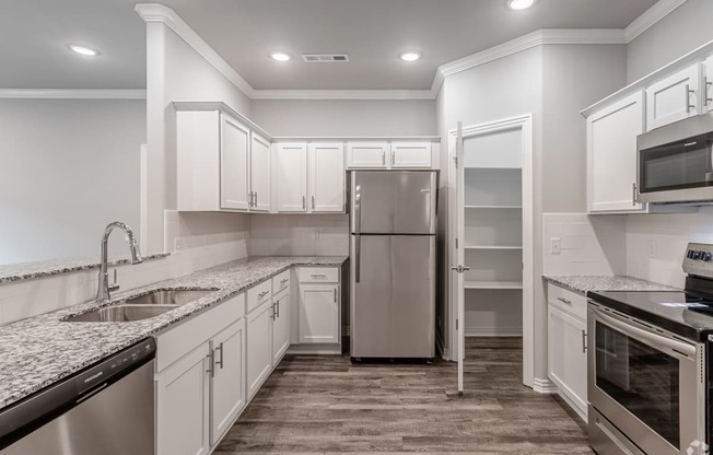 a kitchen with white cabinets and a stainless steel refrigerator