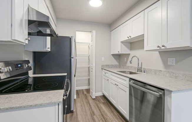 1-Bedroom Apartments in Tukwila, WA - Foster Creek - Kitchen with Marble-Style Countertops, White Cabinets, Large Pantry, and Stainless Steel Appliances