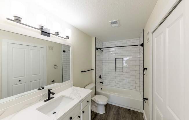 A white bathroom with a sink, toilet, and bathtub.