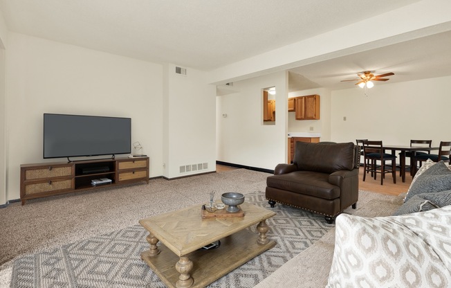 A living room with a brown leather chair and a wooden coffee table.