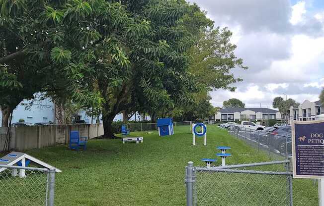 a park with a sign and chairs in the grass