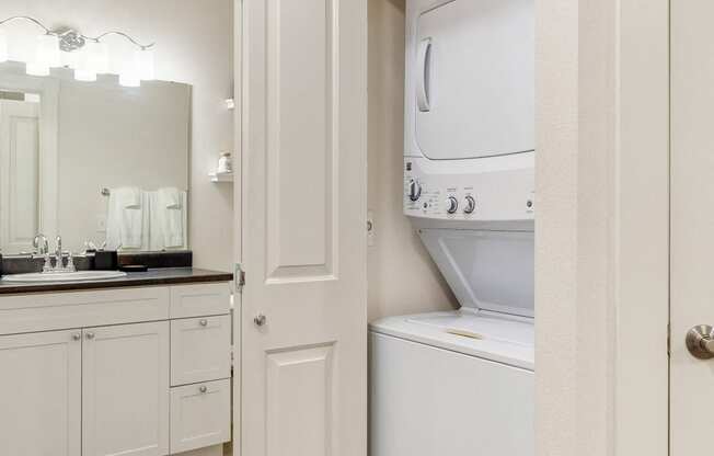 a laundry room with a washer and dryer and a door to the bathroom