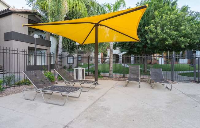 A yellow umbrella shades a row of lawn chairs at Sterling Point Apartment Homes, Arizona