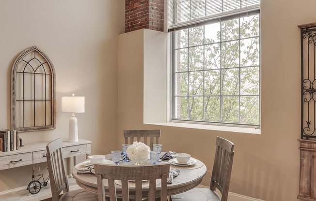 a dining room with a table and chairs and a large window