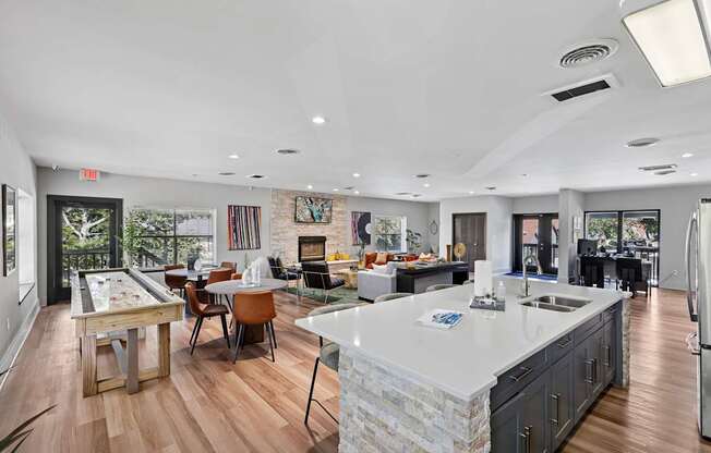 A kitchen with a large island and a dining table with chairs.
