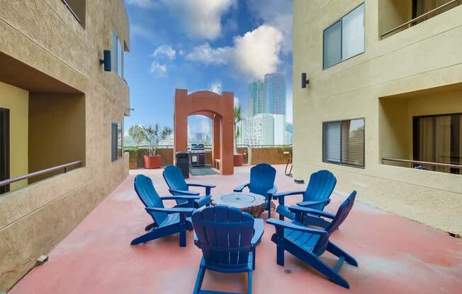 A patio with blue chairs and a table.