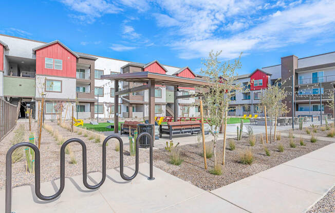 A playground area with a slide and a railing in front of apartment buildings.