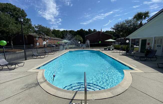 Apartments in North Charleston for Rent - The Retreat at Palm Pointe Apartments Gated Pool Surrounded By Lounging Chairs With Access to Apartments