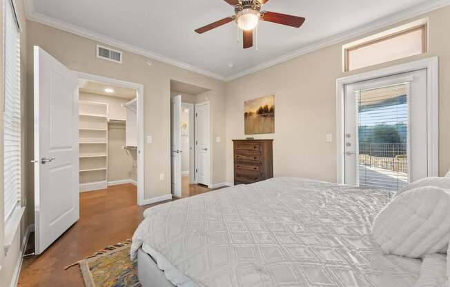 A bedroom with a large bed and a ceiling fan. at Bridge at Heritage Woods, Texas, 78753