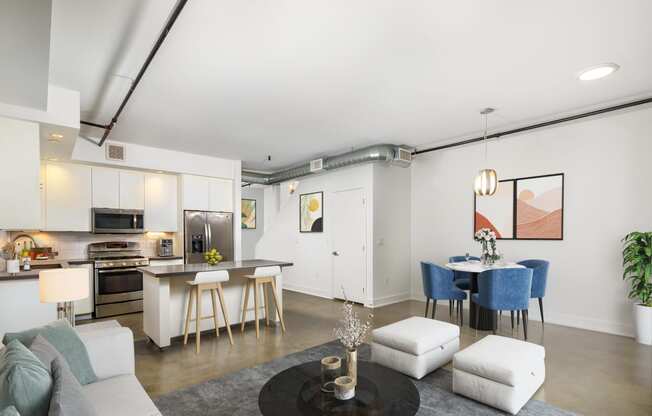 a living room with white walls and a kitchen with a breakfast bar and a dining table