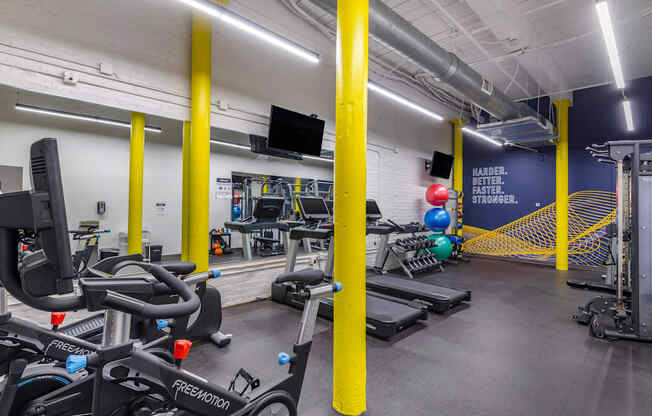 a gym with cardio equipment and weights in a building at Highland Mill Lofts, Charlotte