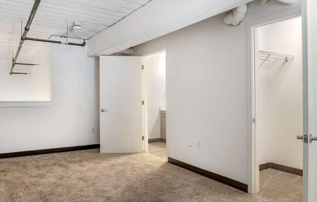 an empty room with white walls and a door to a closet at Highland Mill Lofts, Charlotte, NC
