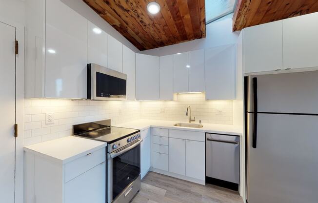 a kitchen with white cabinetry and a wooden ceiling