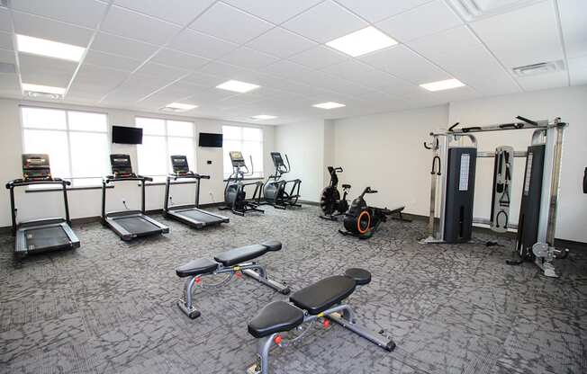 A gym with a variety of equipment including treadmills, exercise bikes, and weight machines.