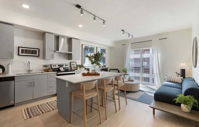 an open kitchen and living room with a large island and a dining table