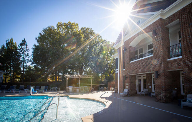 the sun shining over the pool at the resort on a sunny day