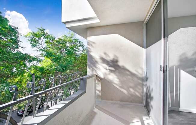 a balcony with a door and a view of a tree