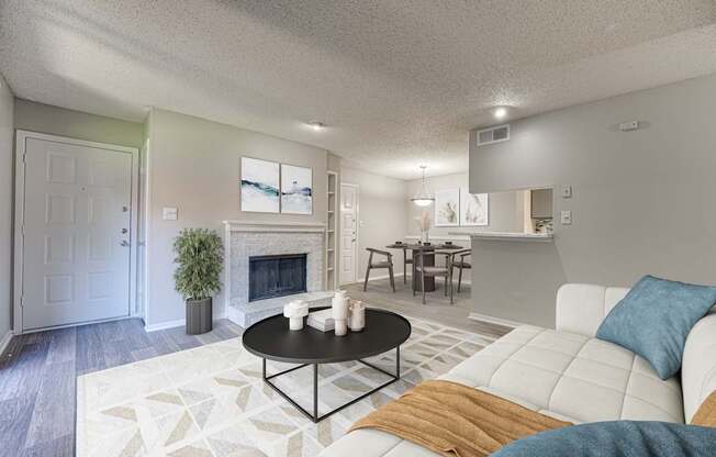 A living room with a white couch and a fireplace.