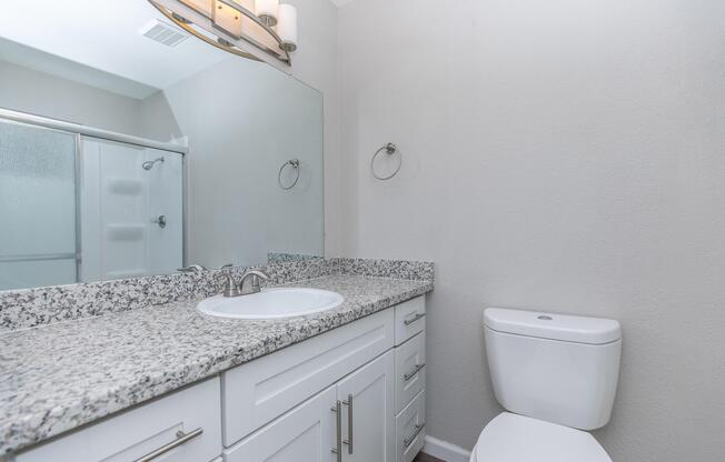 a bedroom area with a sink and a mirror