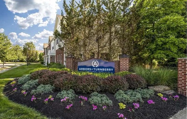 a building with a sign and flowers in front of it