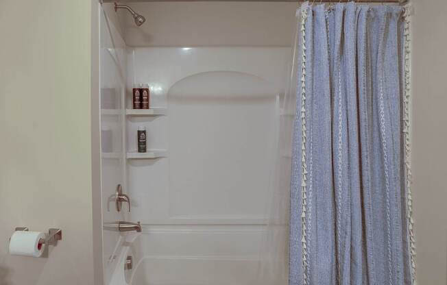 a bathroom with a shower and a blue shower curtain