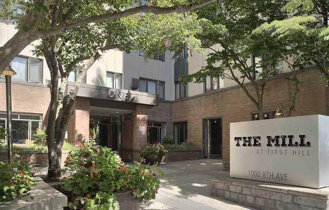The Mill at First Hill is a modern building with a large entrance and a sign at the front.