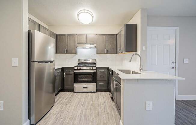 A kitchen with a stainless steel refrigerator and a white countertop at Sterling Point Apartment Homes, Phoenix