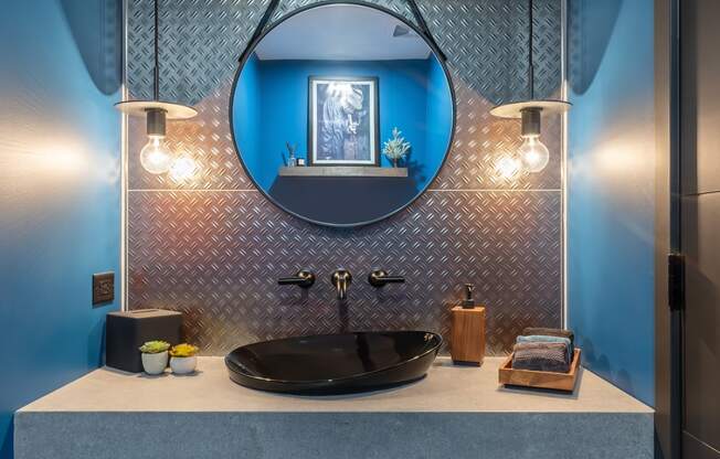 a bathroom with blue walls and a sink and a mirror