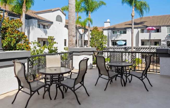 a patio with tables and chairs on a balcony