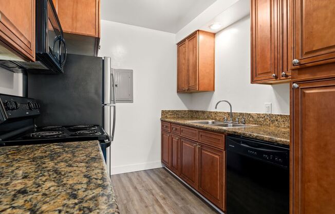 a kitchen with granite counter tops and black appliances
