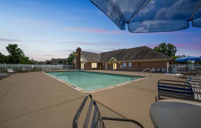 A pool area with a hot tub and a building in the background at Arbors at Georgetown Apartments, Lansing, 48911