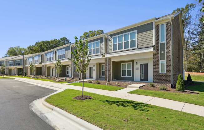 A row of modern houses with a clear blue sky above them.