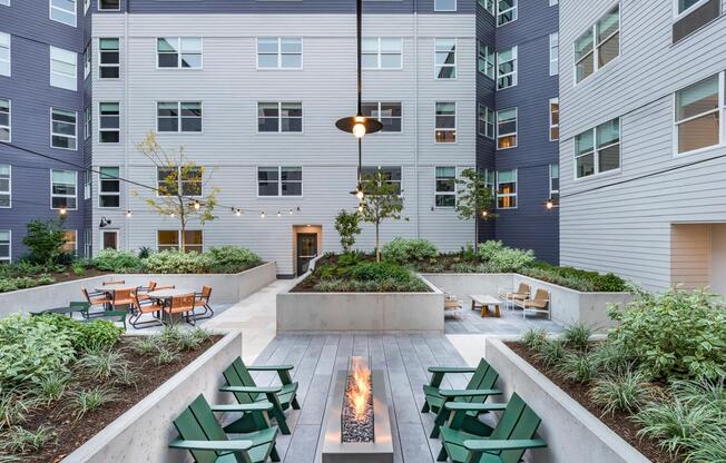 Relax in Modera Woodstock's lush landscaped courtyards with cozy lounge seating and a stylish fire table.