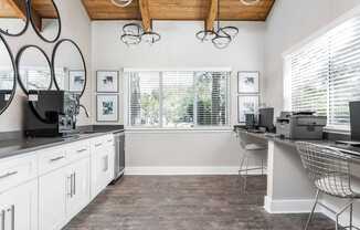 A kitchen with white cabinets and a wooden ceiling.