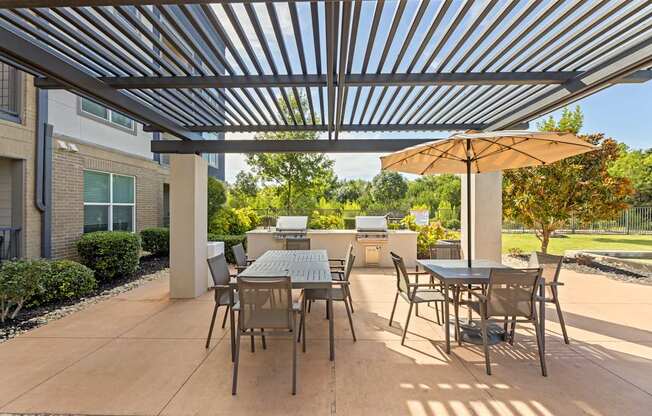 A patio with a table and chairs under a metal roof.
